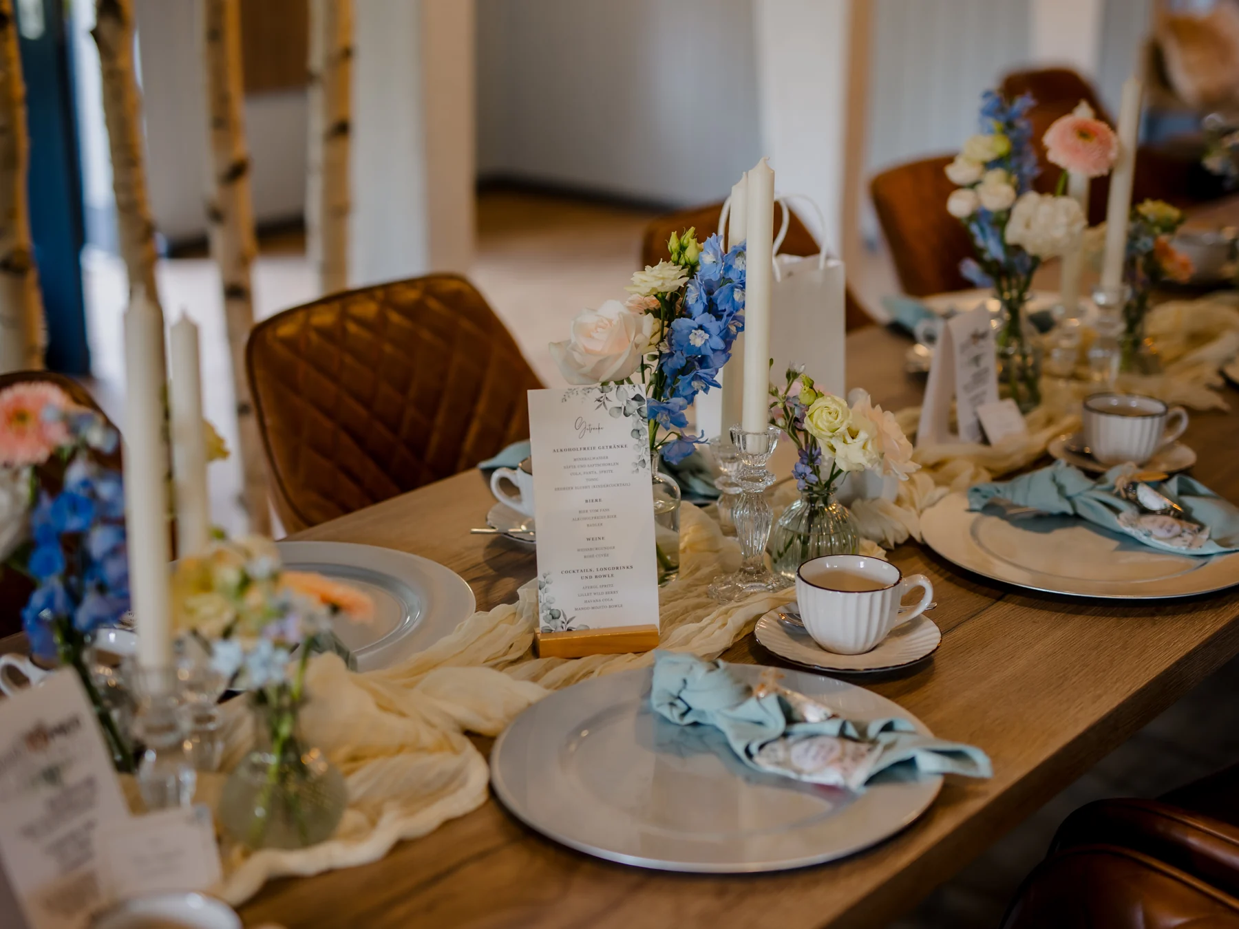 Feines Porzellan und Blumen auf einer gedeckten Tafel