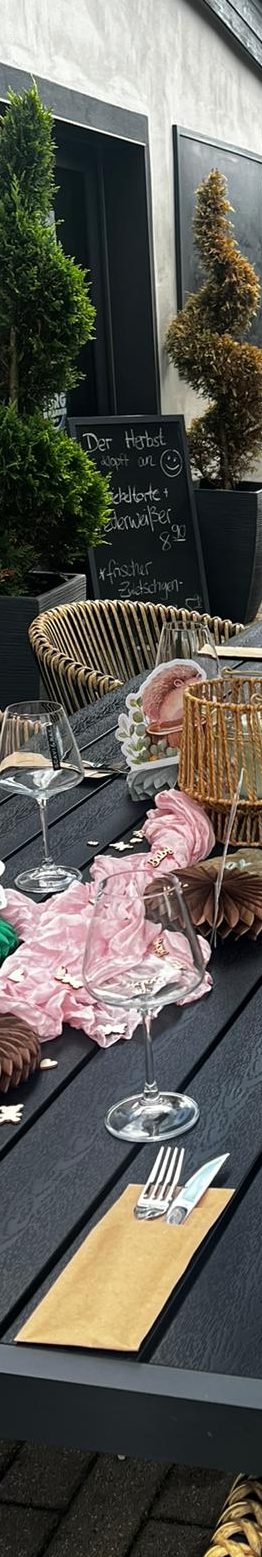 Tischgedeck Ein gedeckter Tisch im Garten mit Essen, Getränken und Dekoration.