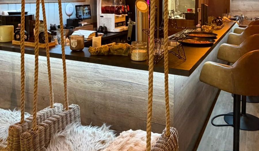 Gemütlicher Café-Bereich mit Schaukelstühlen und einem Bistro-Thekenbereich.