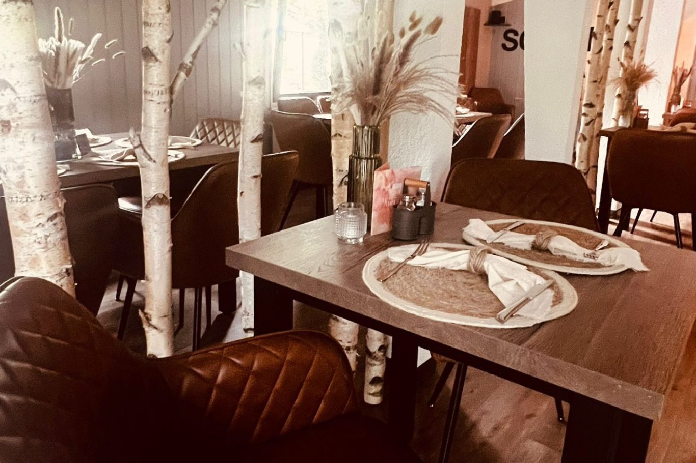 Gemütliches Restaurant mit Holzmöbeln und gedecktem Tisch.