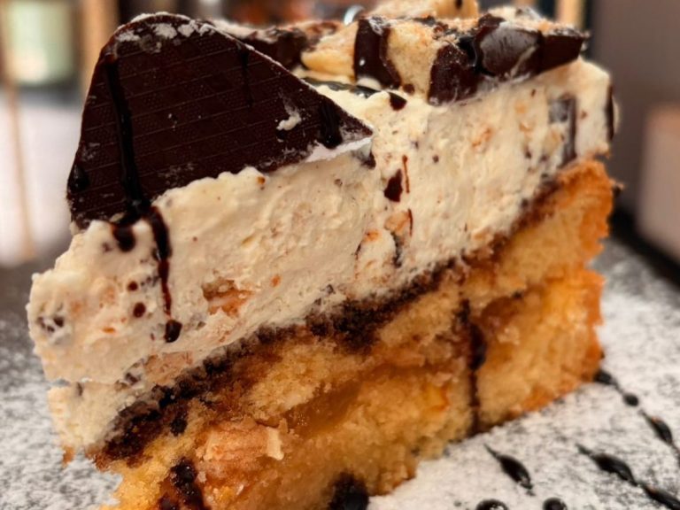 Schichttorte mit cremiger Füllung, Schokoladenglasur und dekorativen Streuseln.