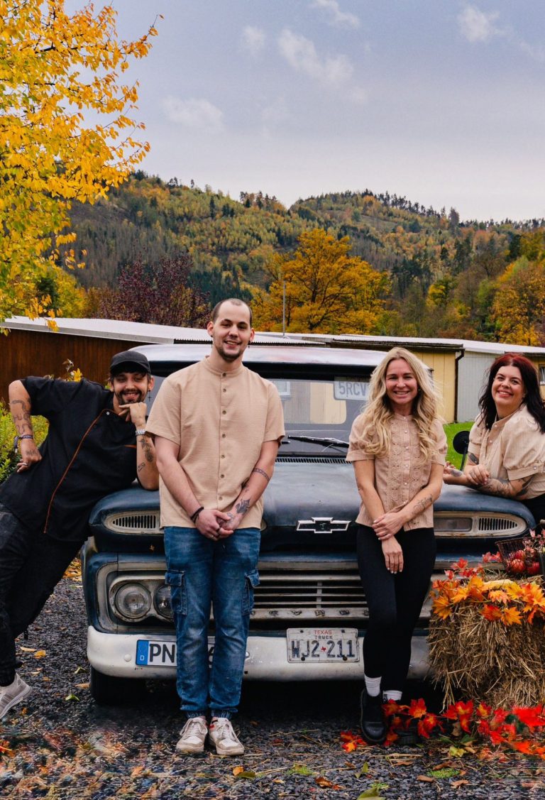 Schmiedehafen Team Vier Personen stehen vor einem alten Truck, umgeben von buntem Herbstlaub.