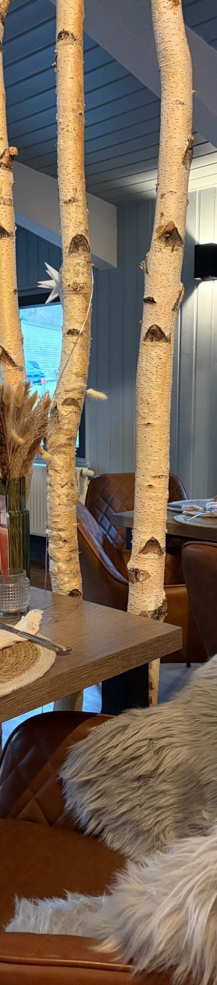 Ein Glas mit braunem Getränk und einer Flasche darüber.